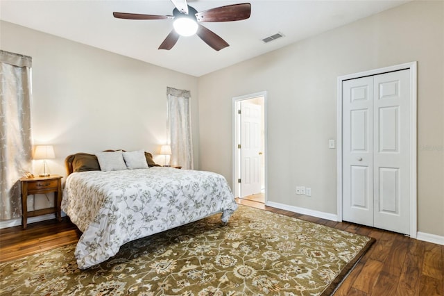 bedroom with dark wood-style floors, ceiling fan, visible vents, and baseboards