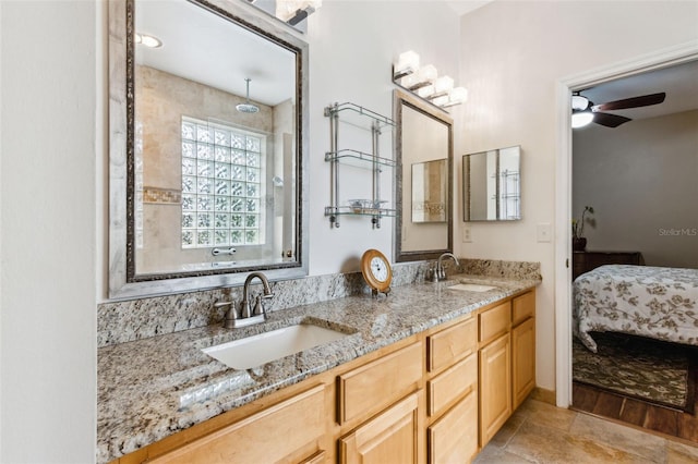 ensuite bathroom with ceiling fan, double vanity, a sink, and connected bathroom