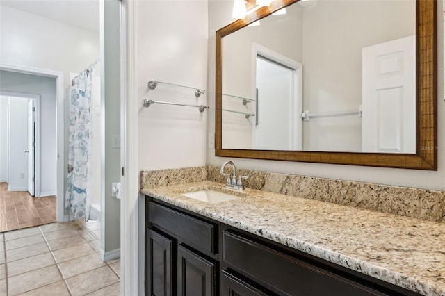 full bath with tile patterned flooring, baseboards, and vanity