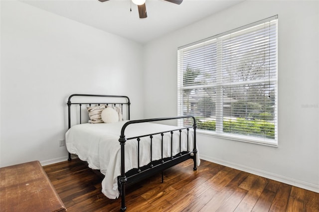 bedroom with a ceiling fan, dark wood-style flooring, and baseboards