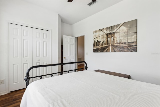 bedroom with dark wood-type flooring, a closet, visible vents, and ceiling fan