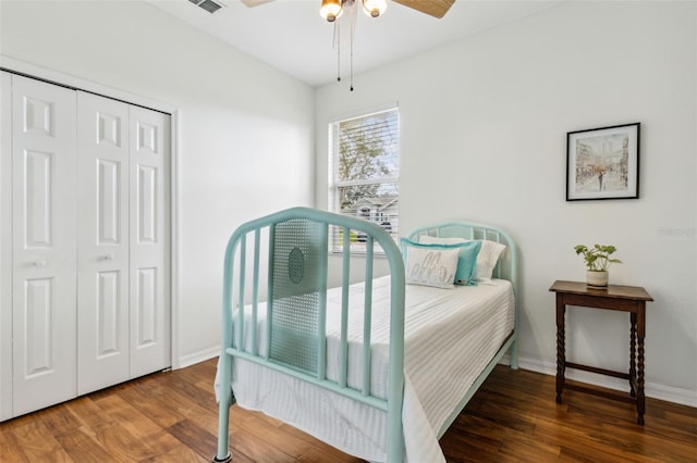 bedroom featuring ceiling fan, dark wood-type flooring, a closet, and baseboards