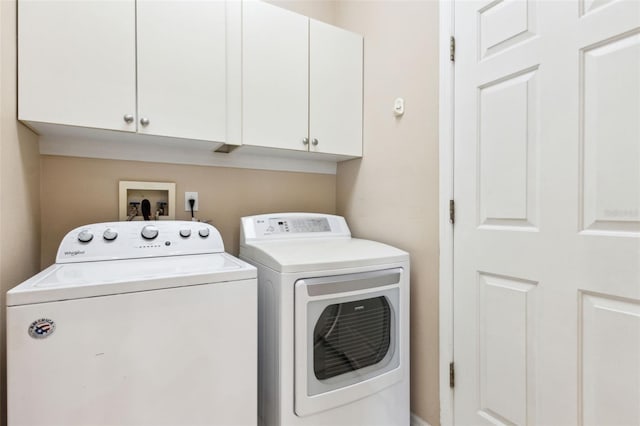 washroom featuring separate washer and dryer and cabinet space