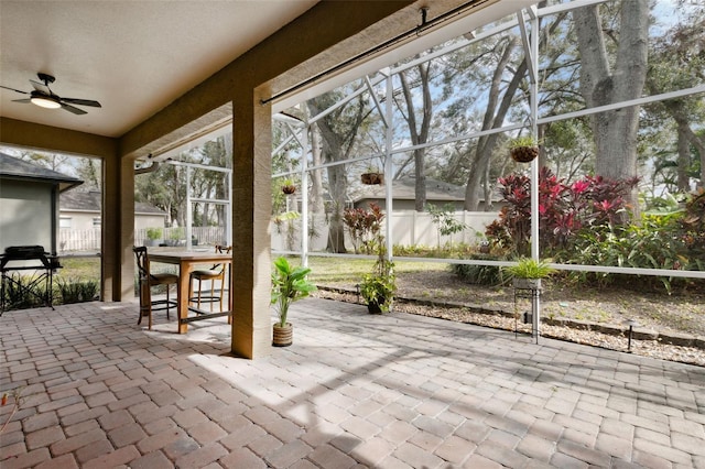 unfurnished sunroom featuring ceiling fan