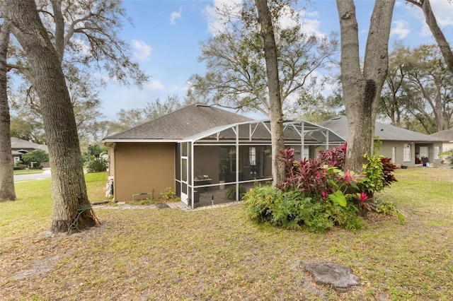 rear view of property with a lanai and a lawn