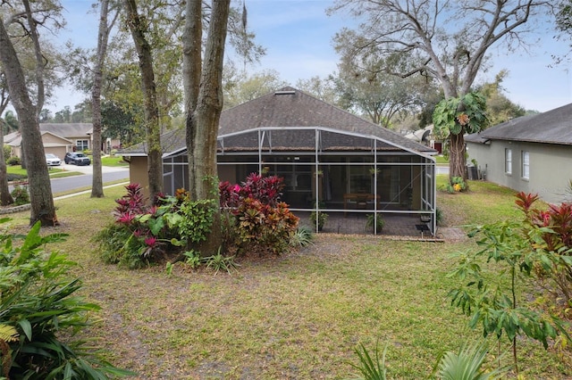 back of property featuring a lawn and a lanai