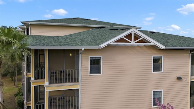 back of house with roof with shingles