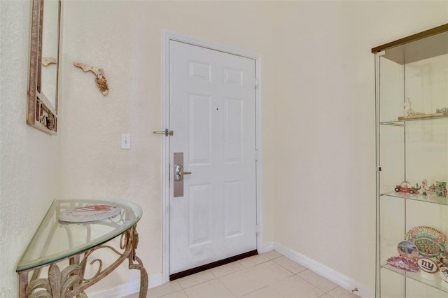 interior space featuring baseboards and light tile patterned flooring