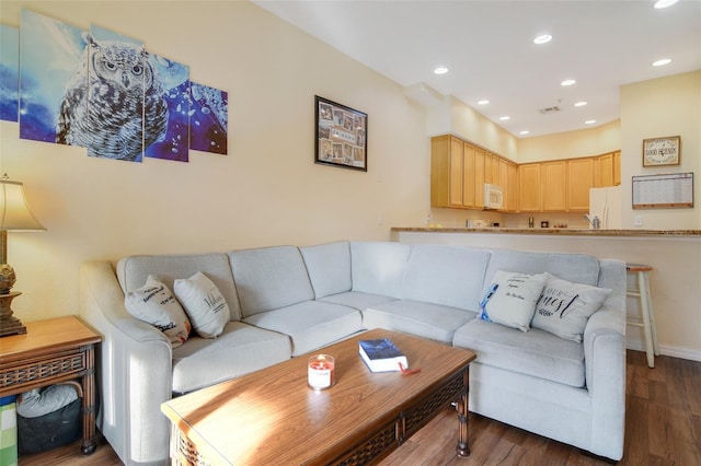 living area with baseboards, wood finished floors, and recessed lighting