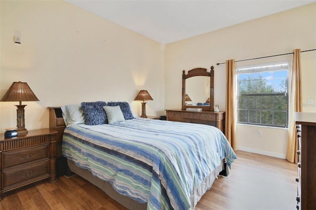 bedroom featuring wood finished floors and baseboards