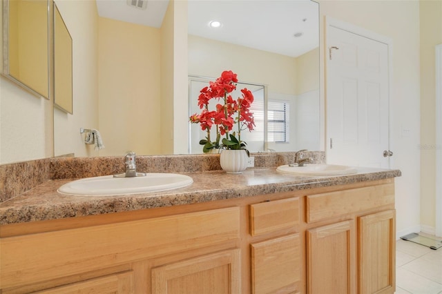 full bath featuring double vanity, visible vents, a sink, and tile patterned floors