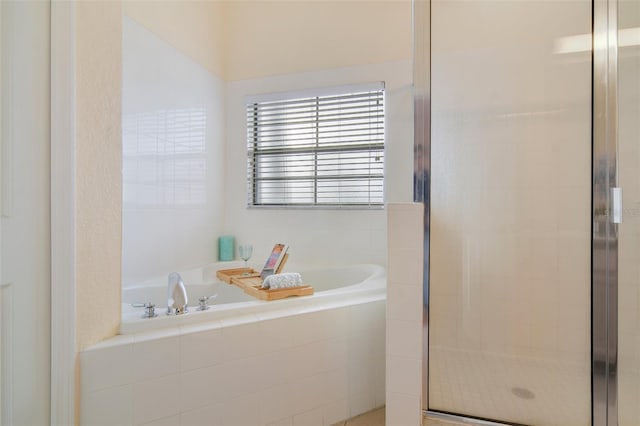 bathroom featuring a shower stall and a bath