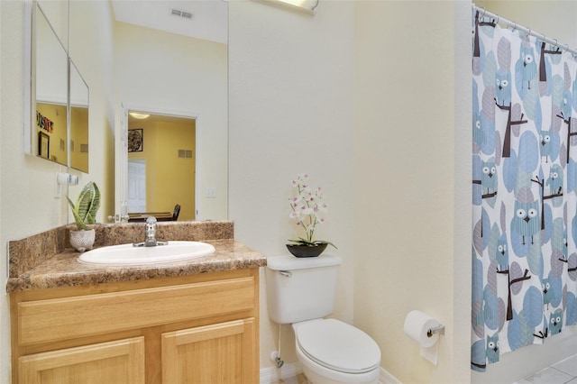 bathroom featuring curtained shower, visible vents, vanity, and toilet