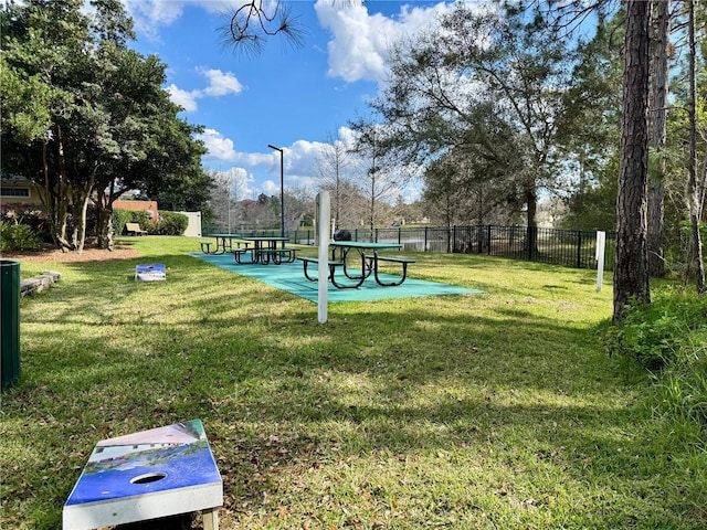 view of community with fence and a lawn