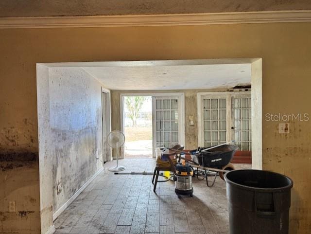 interior space with wood finished floors and crown molding