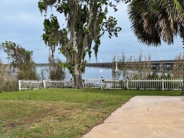 view of yard with a water view and fence