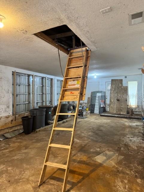 basement featuring a textured ceiling and visible vents