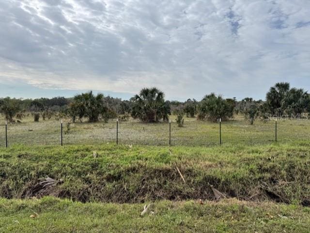 view of yard with a rural view and fence