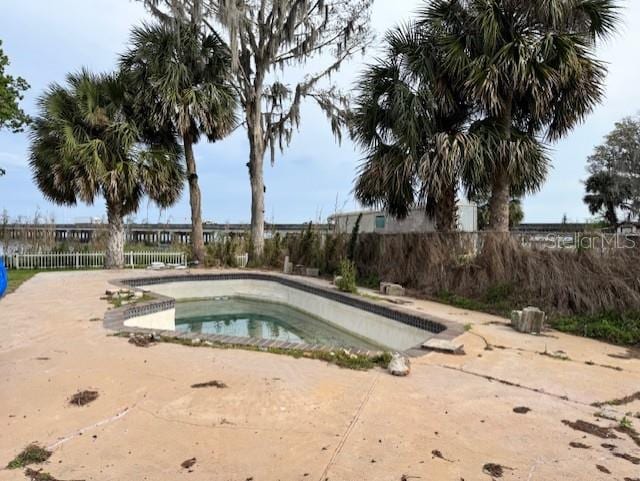 view of swimming pool featuring fence and a patio