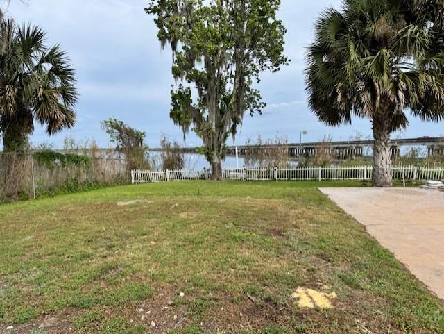 view of yard featuring a water view and fence