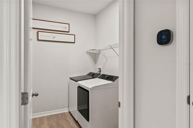 clothes washing area with light wood-style floors, laundry area, hookup for a washing machine, and baseboards