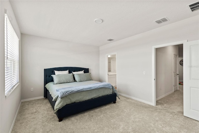 bedroom with light carpet, visible vents, and baseboards