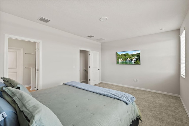 bedroom with light colored carpet, visible vents, and baseboards