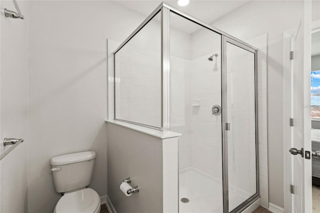 full bath with a shower stall, toilet, and baseboards