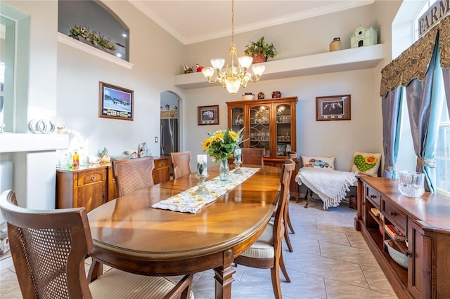 dining room featuring arched walkways, a high ceiling, a chandelier, and crown molding