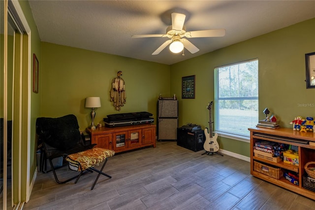 sitting room featuring ceiling fan, baseboards, and wood finished floors