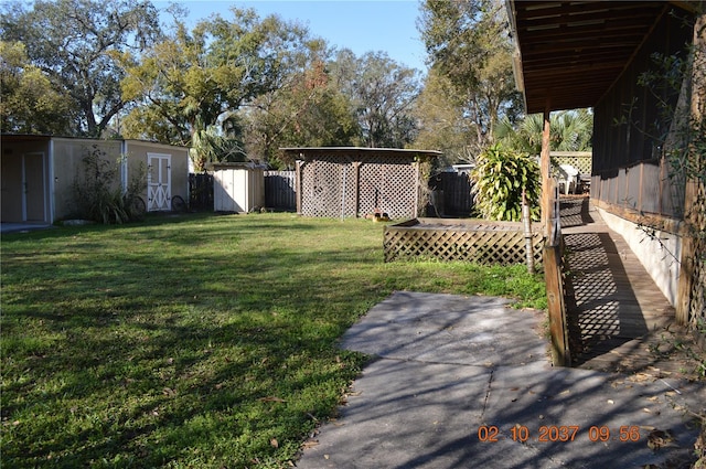 view of yard with an outbuilding, fence, and a storage shed