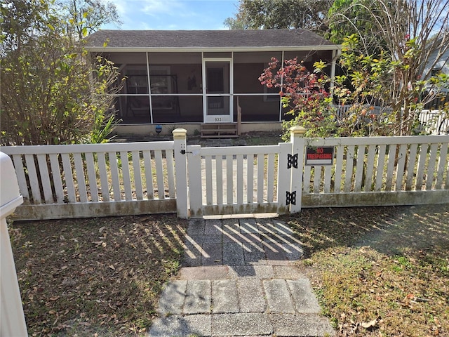 view of front facade featuring a sunroom, a gate, and fence