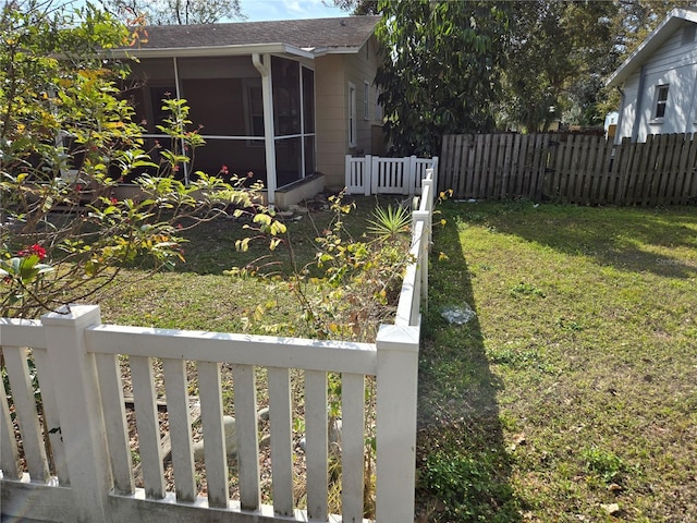 view of yard with fence and a sunroom