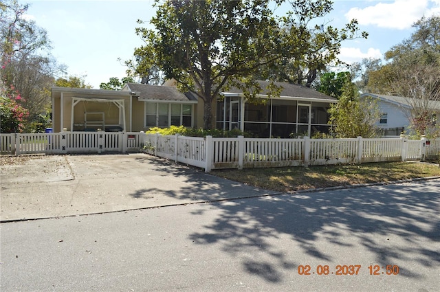 view of front of home featuring a sunroom and a fenced front yard