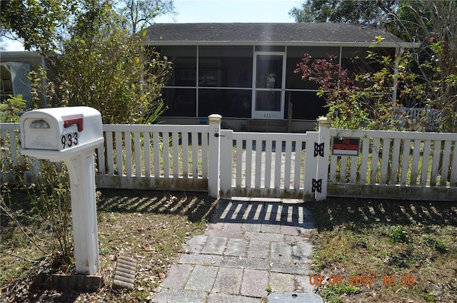 exterior space featuring a sunroom, a gate, and fence