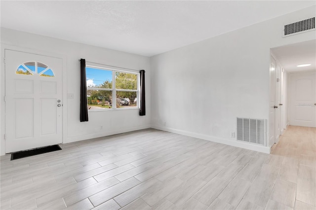 entrance foyer featuring light wood-style floors, baseboards, and visible vents