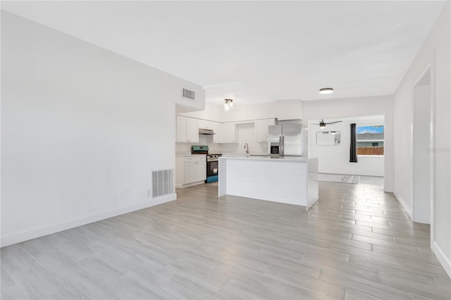 unfurnished living room featuring light wood-style floors, visible vents, ceiling fan, and baseboards