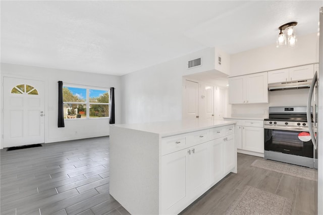 kitchen featuring a center island, stainless steel electric range oven, light countertops, white cabinetry, and under cabinet range hood