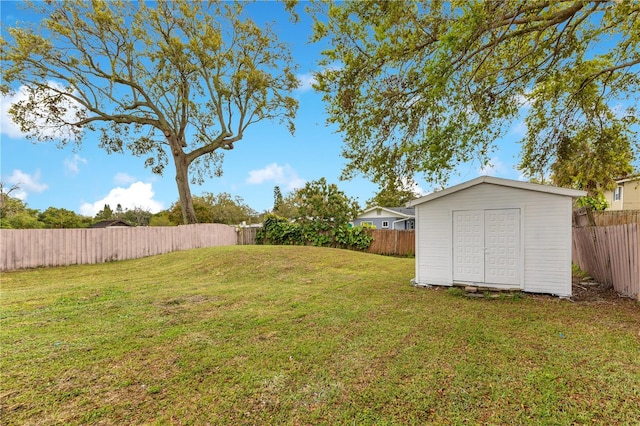 view of yard with a fenced backyard, a shed, and an outdoor structure