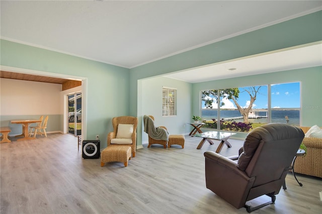 living area with crown molding, baseboards, and wood finished floors