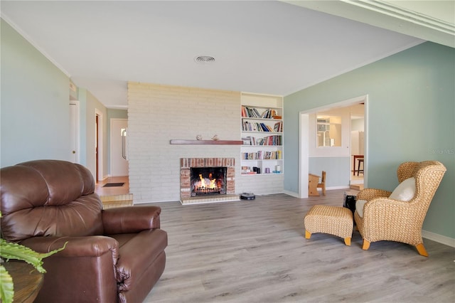 living room with wood finished floors, visible vents, and crown molding