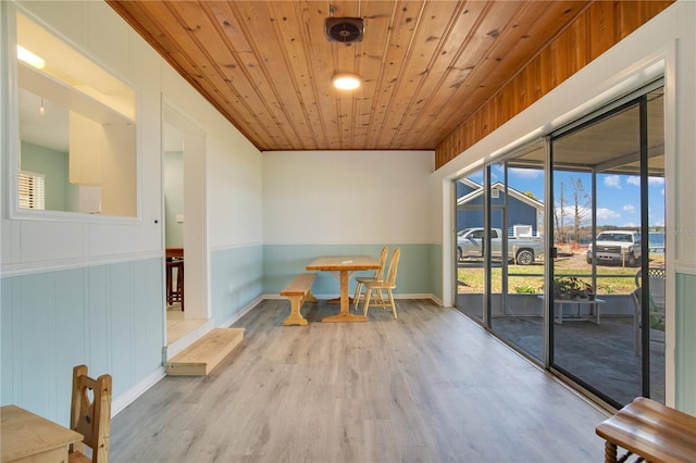 dining space with wooden ceiling, visible vents, a wainscoted wall, and wood finished floors