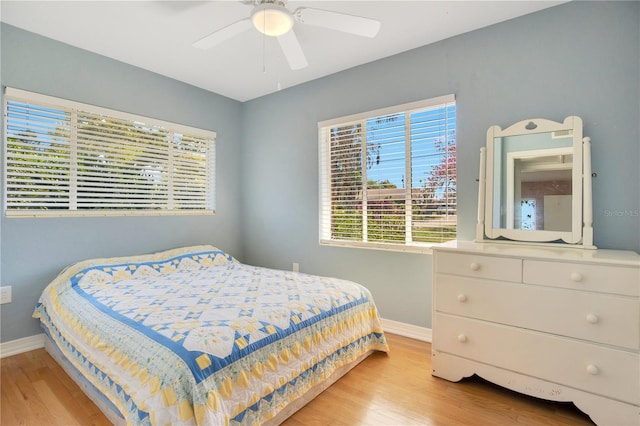 bedroom with wood finished floors, a ceiling fan, and baseboards