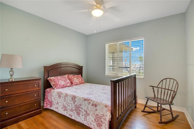 bedroom with wood finished floors, a ceiling fan, and baseboards