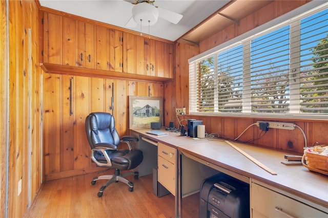 office area with ceiling fan, light wood finished floors, wood walls, and a wealth of natural light