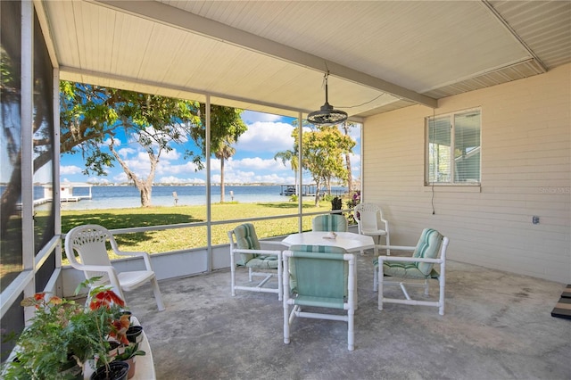 sunroom featuring a water view