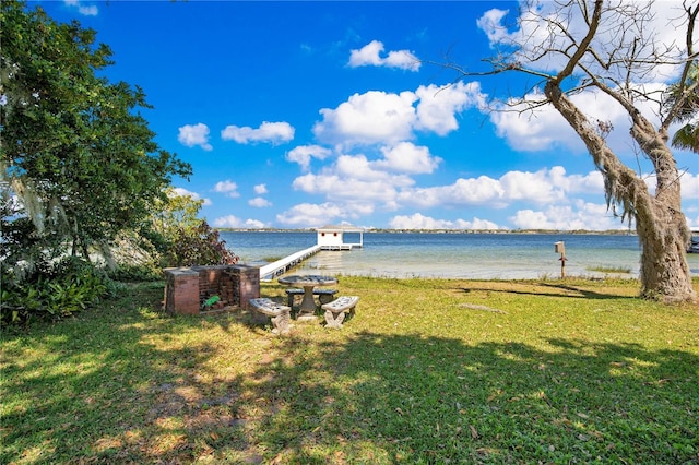 view of yard with a water view and a boat dock