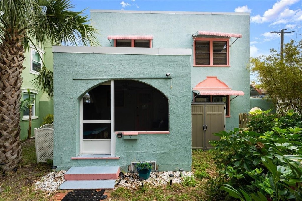 back of property featuring entry steps and stucco siding