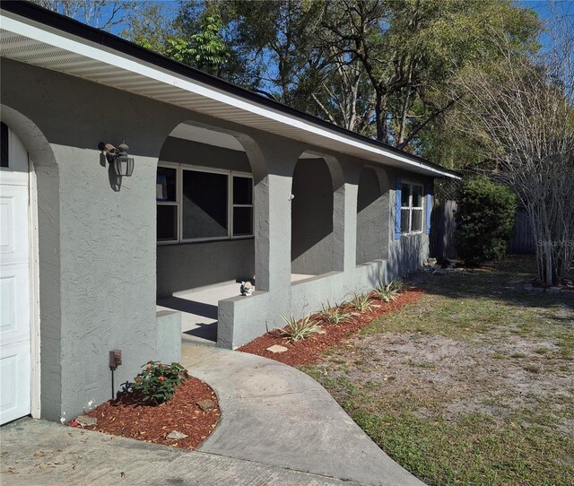 view of side of property featuring stucco siding and a garage