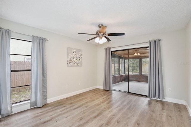 spare room featuring ceiling fan, a textured ceiling, baseboards, and wood finished floors